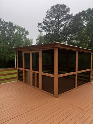 Newly stained wooden deck stairs with black metal railings and a warm honey finish.