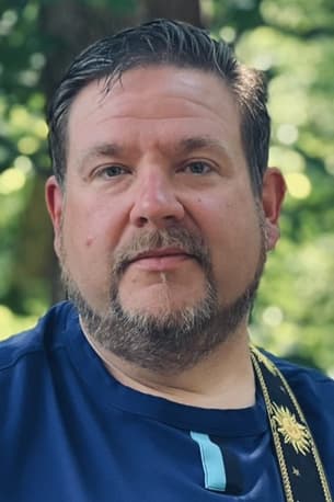 Jeremy Barr smiling holding a piece of wood