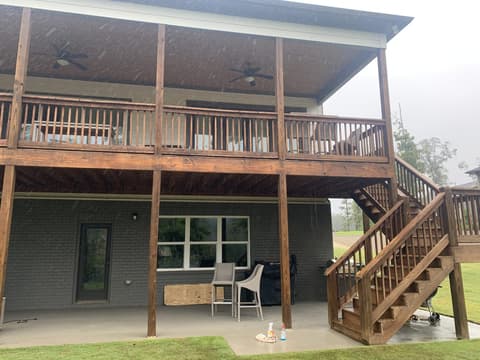 Newly stained wooden deck stairs with black metal railings and a warm honey finish.