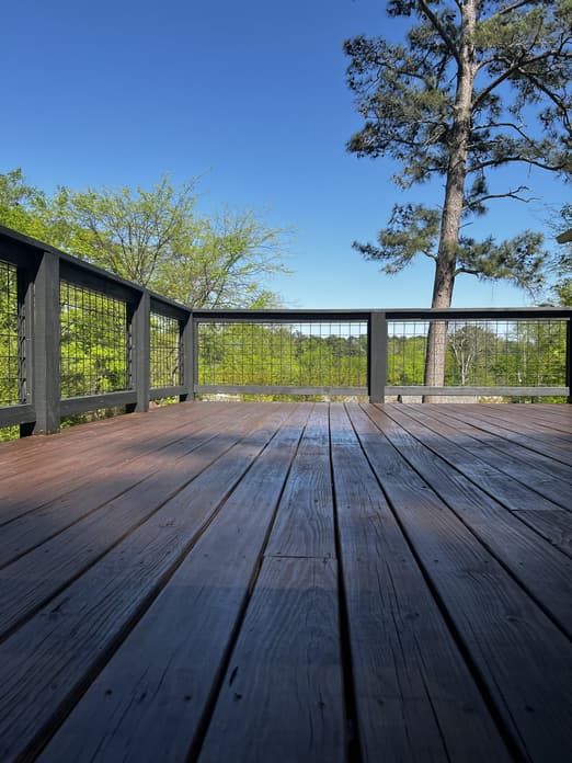 Rebuilt deck with homeowner smiling