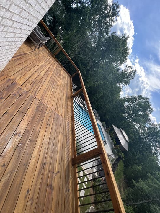 An expert deck builder inspecting a wooden deck structure for rebuilding readiness.